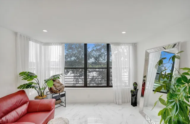 a living room with furniture a window and a flat screen tv