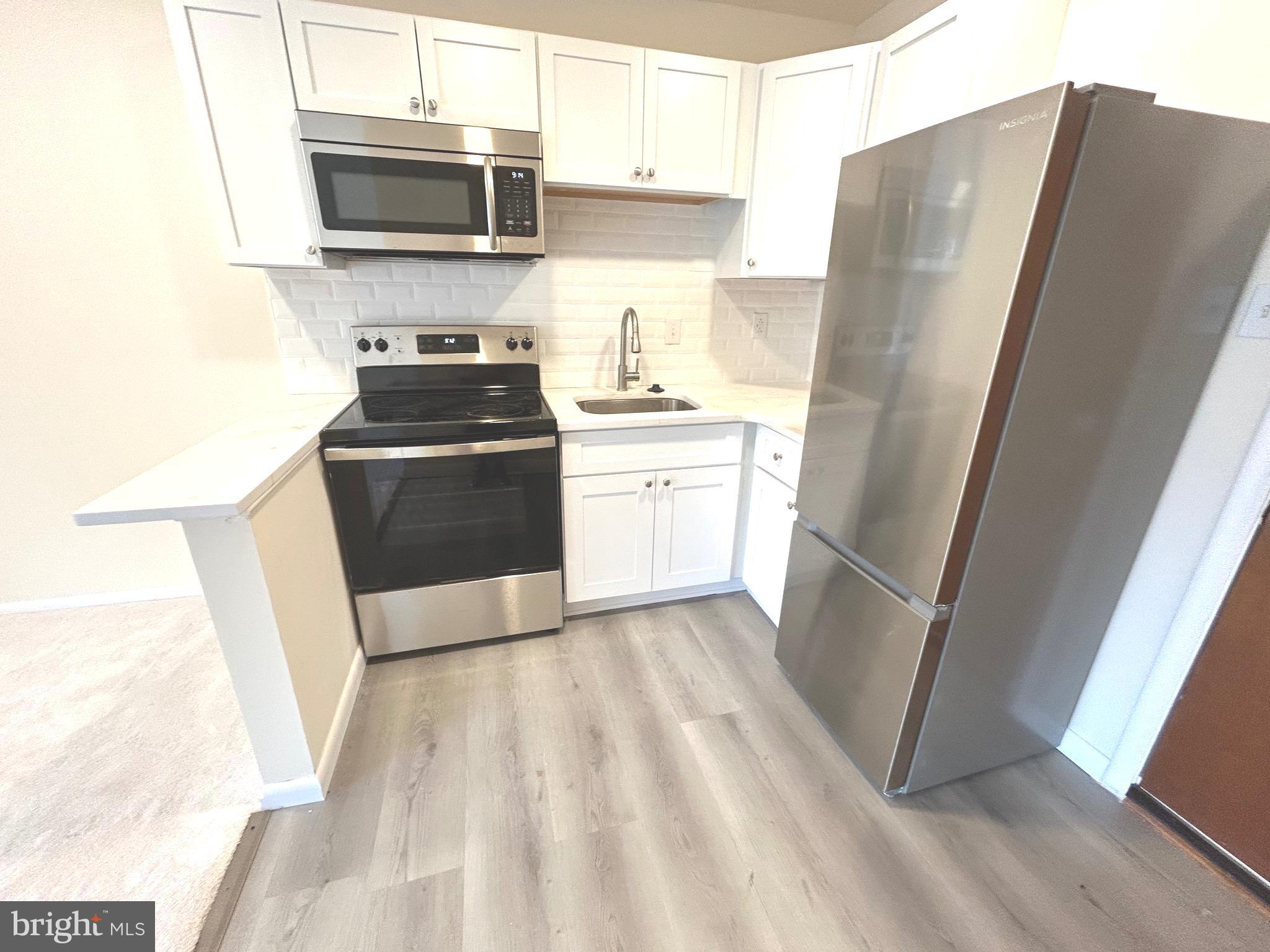 7 Rockford Road, Unit K022 Wilmington, DE 19806 - Photo 3 of 15 a kitchen with stainless steel appliances a refrigerator sink and microwave