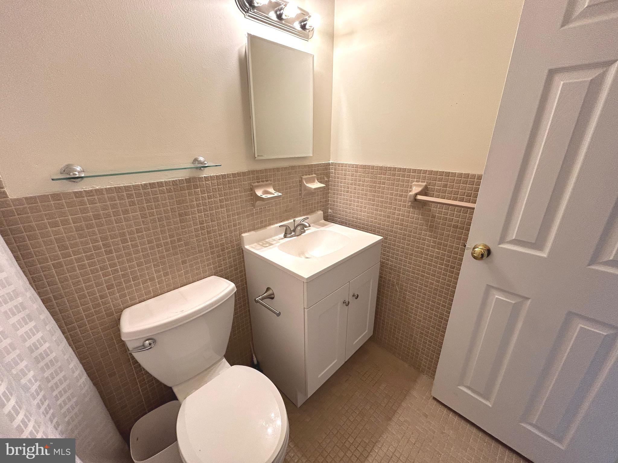 7 Rockford Road, Unit K022 Wilmington, DE 19806 - Photo 10 of 15 a bathroom with a toilet sink and mirror