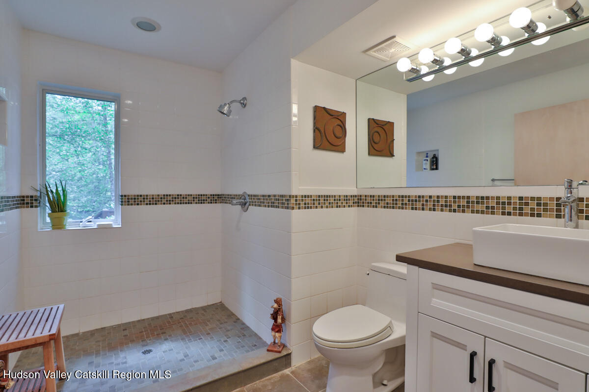 3 Quarry Road Shandaken, NY 12480 - Photo 24 of 29 a bathroom with a granite countertop sink a mirror and a toilet