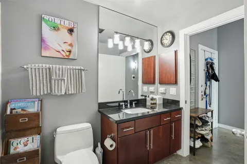 a bathroom with a granite countertop sink mirror vanity and toilet