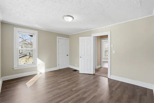 an empty room with wooden floor and window
