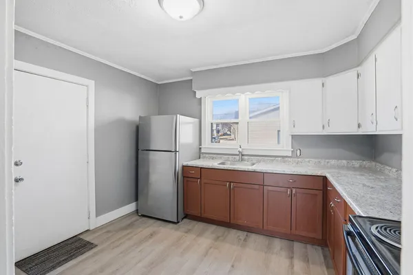 a kitchen with a sink a refrigerator and cabinets