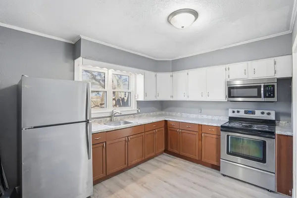 a kitchen with stainless steel appliances granite countertop a refrigerator sink stove microwave and cabinets