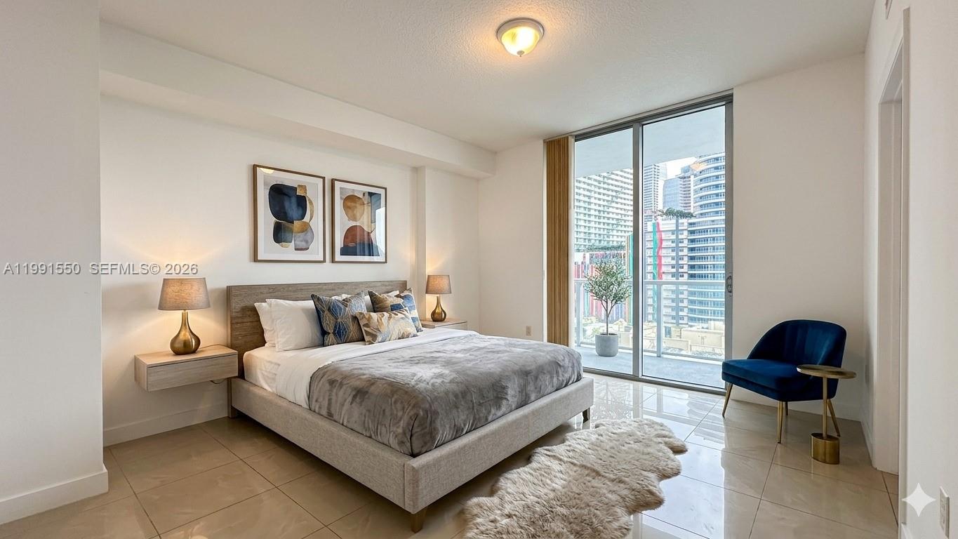 79 Southwest 12th Street, Unit 1102S Miami, FL 33130 - Photo 10 of 24 a bedroom with a bed a chair and a large window