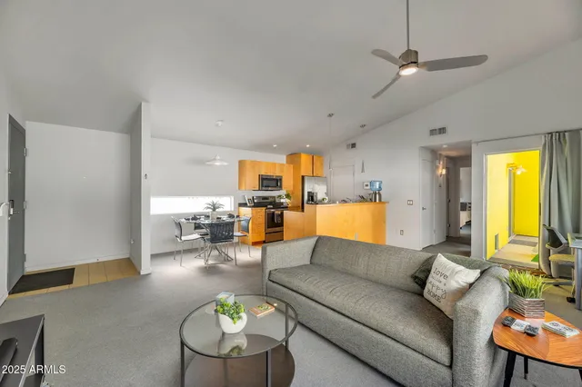 a living room with furniture kitchen view and a chandelier