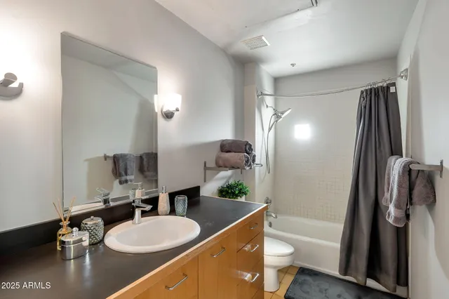 a bathroom with a granite countertop sink toilet a mirror and shower
