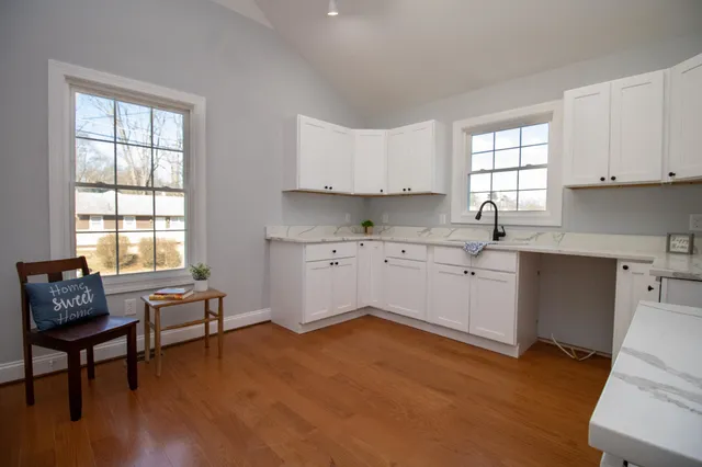 a kitchen with a window a sink dishwasher a dining table and chairs with wooden floor