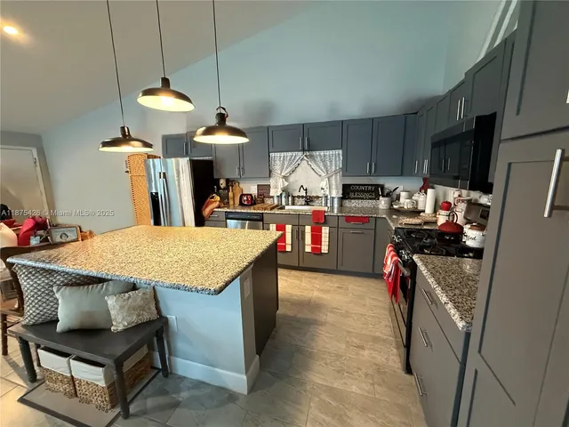 a kitchen with kitchen island a stove and a refrigerator