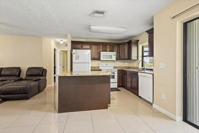 a kitchen with stainless steel appliances granite countertop a stove top oven a sink a counter space and cabinets