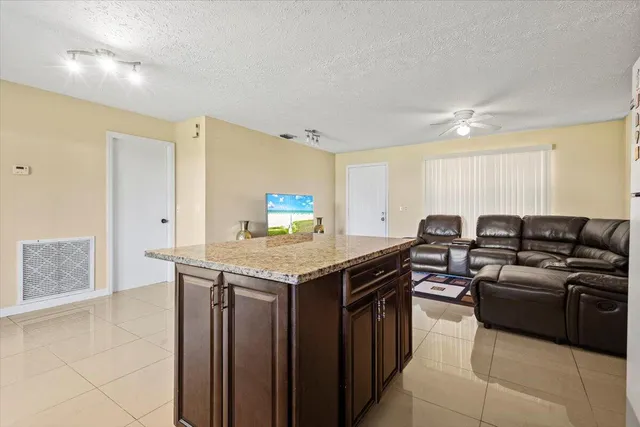 a open kitchen with stainless steel appliances granite countertop a stove and a sink