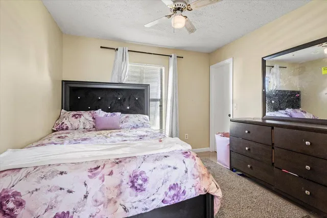 a bedroom with a bed and a mirror on dresser