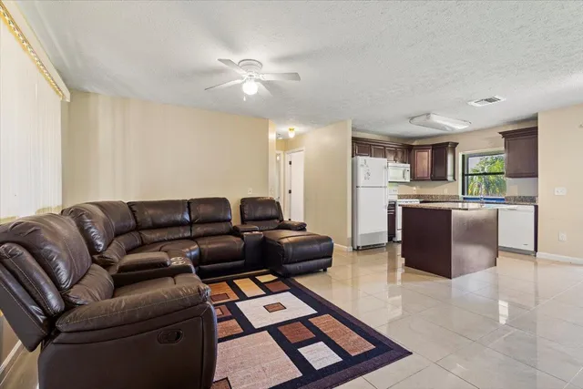 a living room with furniture and kitchen view