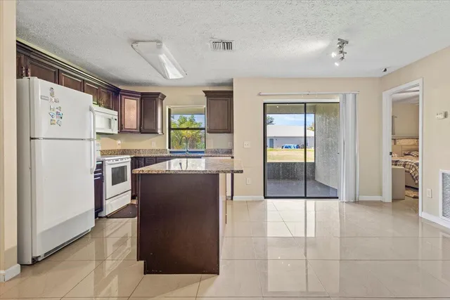 a kitchen with stainless steel appliances granite countertop a refrigerator and a stove top oven