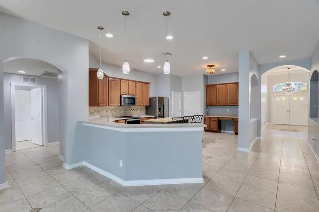 a kitchen with stainless steel appliances granite countertop wooden cabinets a stove top oven a sink and dishwasher