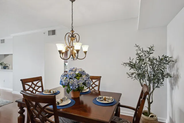 a dining room with furniture wooden floor a chandelier