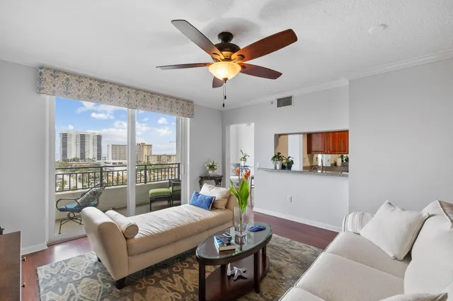 a living room with furniture a flat screen tv and a large window