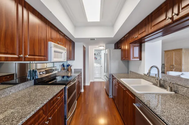 a kitchen with stainless steel appliances granite countertop a sink refrigerator and cabinets