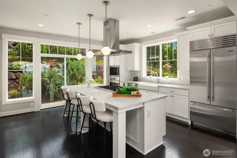 a kitchen with stainless steel appliances granite countertop a stove a kitchen island a table and chairs
