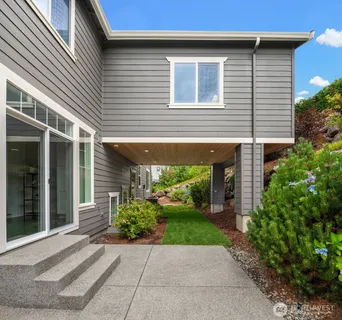 a view of a porch with a yard potted plants and floor to ceiling window