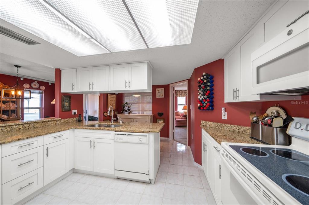 3954 Sailmaker Lane Holiday, FL 34691 - Photo 11 of 24 a kitchen with a sink stove and cabinets