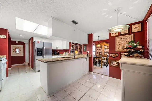 a kitchen with stainless steel appliances granite countertop a refrigerator and a stove top oven