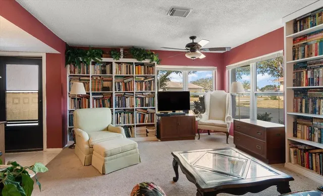 a living room with furniture a flat screen tv and a book shelf