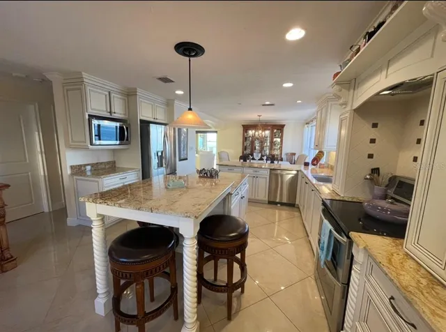 a kitchen with stainless steel appliances granite countertop a sink a stove and a refrigerator