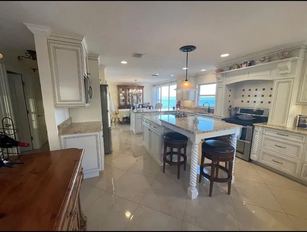 a kitchen with kitchen island granite countertop wooden cabinets and a refrigerator