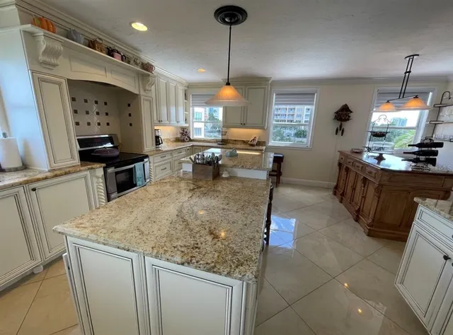 a kitchen with stainless steel appliances granite countertop sink stove and refrigerator