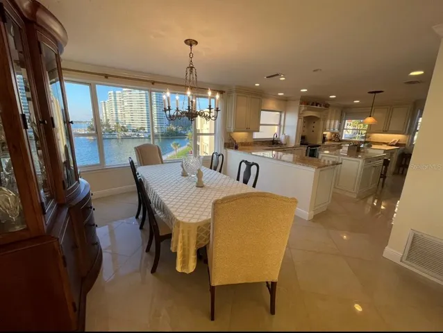 a dining room with furniture a chandelier and wooden floor