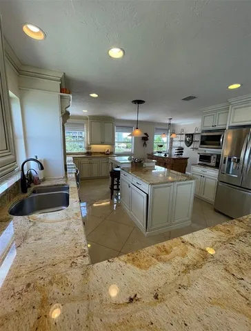 a kitchen with stainless steel appliances granite countertop a stove sink and cabinets