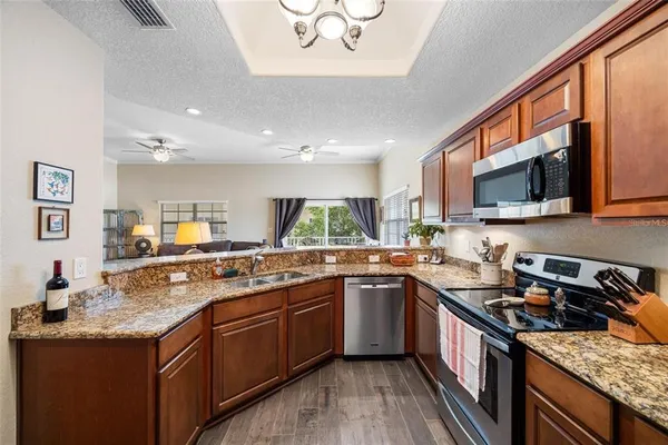 a kitchen with stainless steel appliances granite countertop a refrigerator and a stove top oven