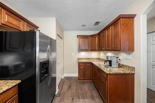 a kitchen with stainless steel appliances granite countertop a refrigerator a stove top oven a sink and dishwasher
