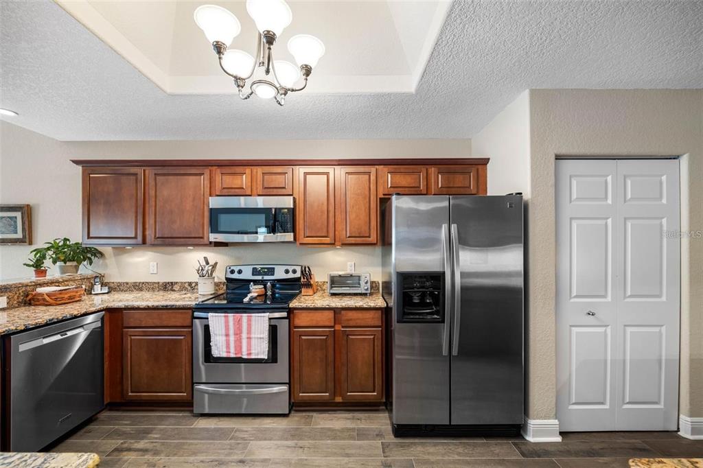 146 175th Terrace Drive East Redington Shores, FL 33708 - Photo 15 of 51 a kitchen with stainless steel appliances granite countertop a refrigerator a stove top oven a sink and dishwasher