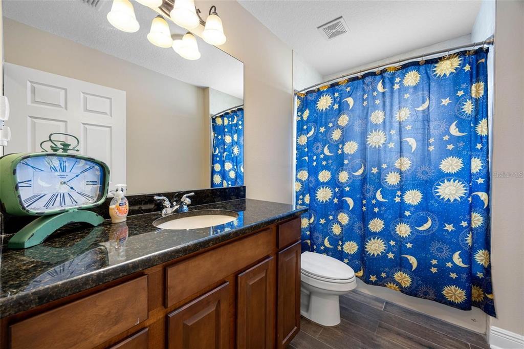 146 175th Terrace Drive East Redington Shores, FL 33708 - Photo 16 of 51 a bathroom with a granite countertop sink a toilet and a mirror