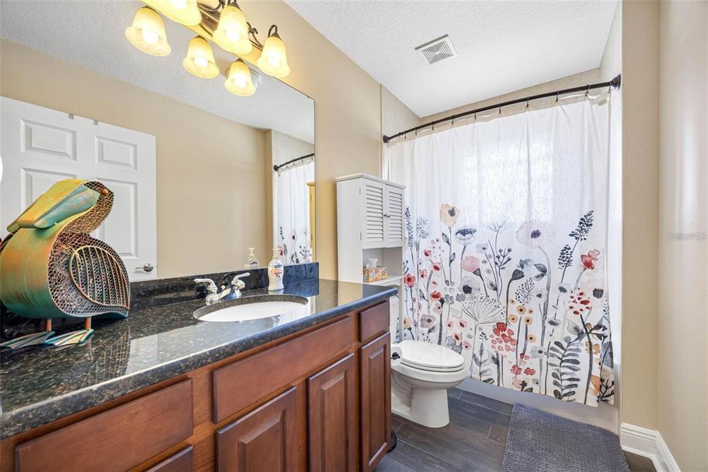 146 175th Terrace Drive East Redington Shores, FL 33708 - Photo 29 of 51 a bathroom with a granite countertop sink a toilet and a mirror