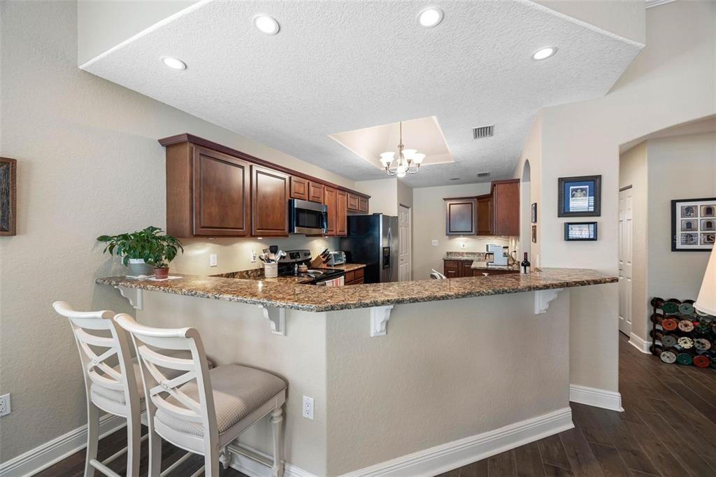 146 175th Terrace Drive East Redington Shores, FL 33708 - Photo 10 of 51 a kitchen with stainless steel appliances granite countertop a sink a stove a refrigerator cabinets and chairs