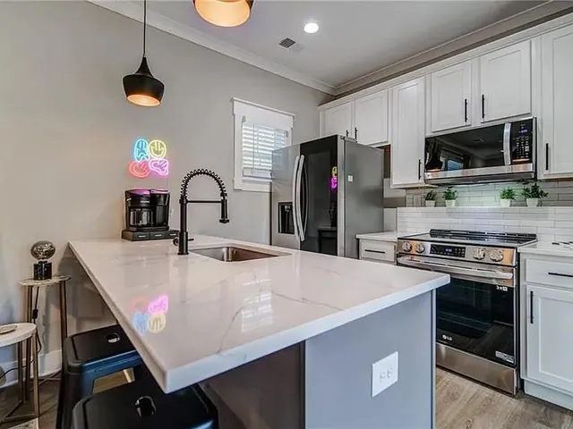 a kitchen with a stove a sink and a refrigerator