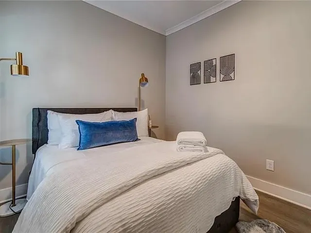 a bedroom with a bed and painting on the wall