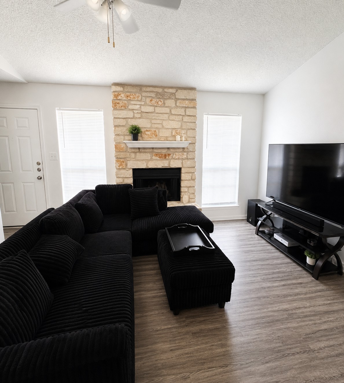 2013 Margalene Way Austin, TX 78728 - Photo 10 of 19 A cozy living space features a captivating stone fireplace, perfect for intimate gatherings.