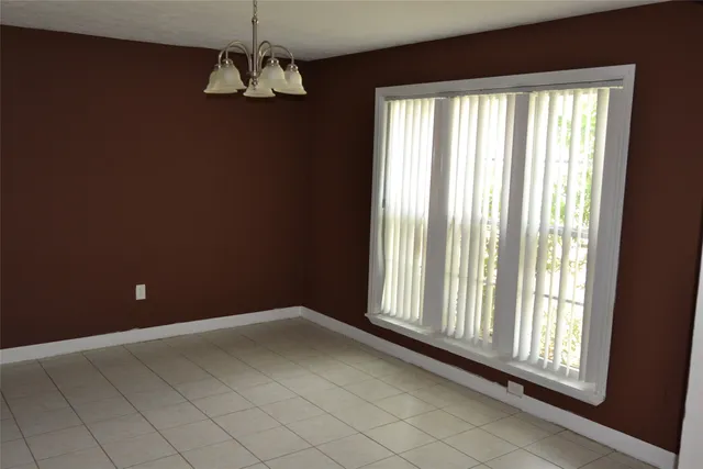 a view of a livingroom with a chandelier fan and windows
