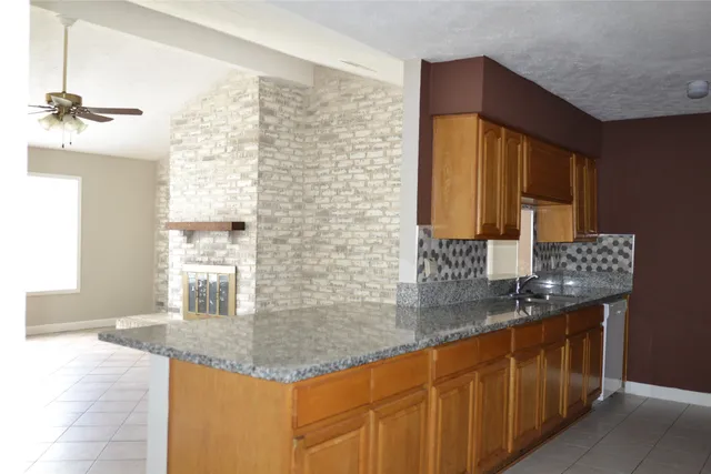 a bathroom with a granite countertop sink a mirror and shower