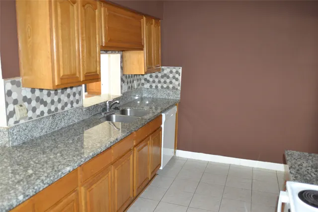 a kitchen with granite countertop cabinets and window