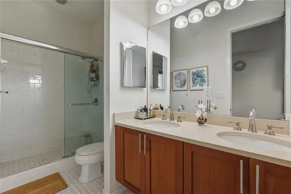 a bathroom with a double vanity sink toilet and shower
