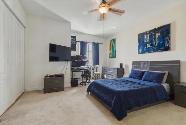 a spacious bedroom with a bed and a flat screen television