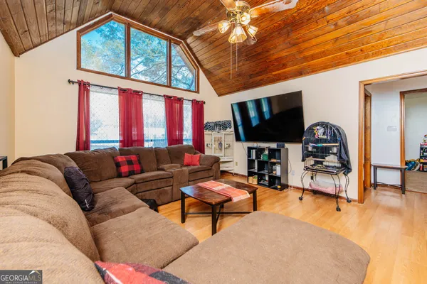 a living room with furniture a window and a flat screen tv