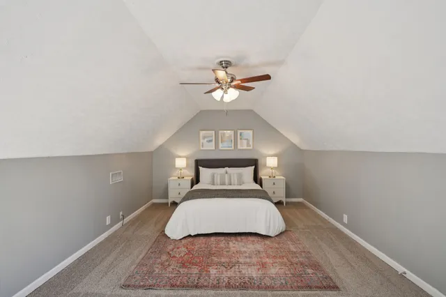 a bedroom with a large bed and a chandelier