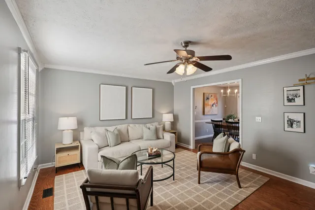 a living room with furniture and a ceiling fan