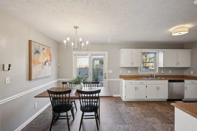 a view of a dining room with furniture and chandelier